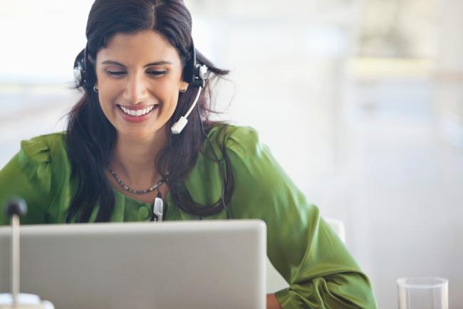 Close up of woman with headset and laptop