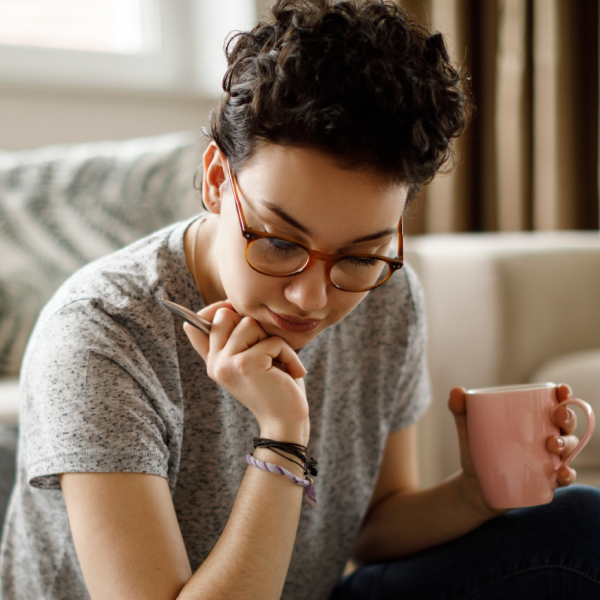 Woman holding mug and pen