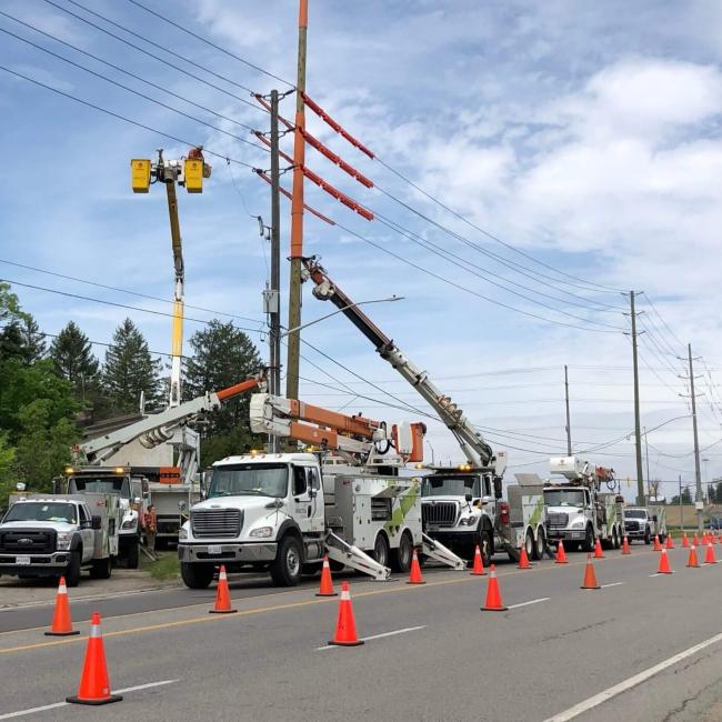 Alectra trucks and engineers working on a pole.